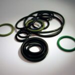 Set di O-ring e guarnizioni nere e verdi di diverse dimensioni su fondo chiaro